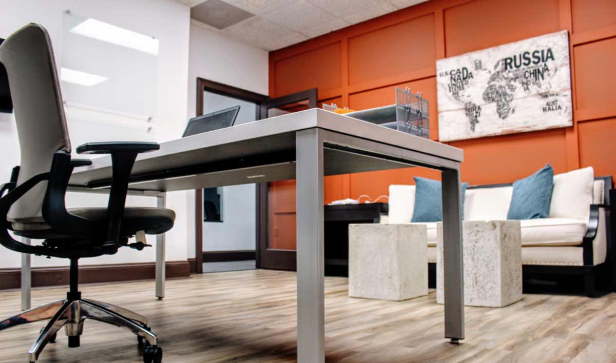 Interior of Atlanta Exec Suite's office space ready for a business owner to work.  Modern furniture with clean lines, high ceilings, and artwork.